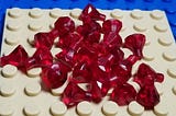 White and blue Lego pieces with some ruby pins