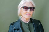 Elderly woman in sunglasses and leather jacket