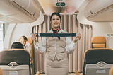 Photo of a flight attendant demonstrating safety measures.