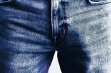 Shot of a man wearing jeans. We can only see the crotch area and an outline of a penis.