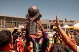 Group of young football players holding up a trophy from the Homeless World Cup