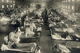 Sick soldiers laying in beds being attended by nurses