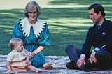 Princess Diana, Prince Charles and Prince William, are seated on a blanket on the lawn