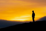 Silhouette of a man against a sunset backdrop.