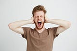 Man with hands over his ears shouting