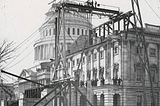 Black and white photo of the Capitol building in Washington DC under construction. There’s plenty of scaffolding around.