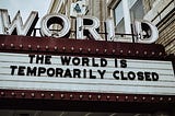 Photo of a Cinema front displaying “The World is temporarily closed”