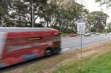 A Muni bus zooms by in an HOV lane on Park Presidio.