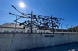 sculpture of people on a pole inside Dachau camp