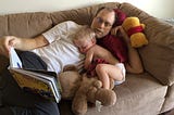 A dad reads to his toddler son.