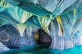 Photograph of Marble caves in the Patagonia region of Chile in tones of Deep Blue, turquoise, aquamarine, grey and striking yellow colored tones.
