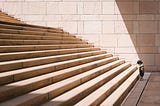 Child standing at the bottom of a long set of stairs