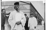 Bengali poet Rabindranath Tagore visits Japan, 1916. He is seen in the foreground, behind him there are other men, two facing the camera.