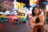 Young beautiful Asian tourist woman with arms crossed at Chinatown in Bangkok