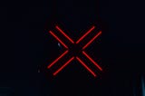 A red X sign glowing in the dark