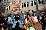 Dawn Cheung and Victoria Do clap and cheer while listening to speakers during a protest against anti-Asian hate crimes at Hing Hay Park in the Chinatown-International District of Seattle, Washington, March 13, 2021.