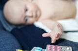 Sick baby reaches for medication