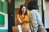 Two women shaking hands in an office.