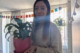 Photo of young woman holding a plant.