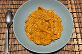 Bowl of shells in a creamy sauce with fake mince meat pieces in it.