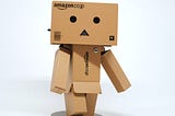 A cardboard creature with fearful expression made of Amazon boxes