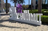 White 3-D lettering and purple sunburst logo spelling out ASU+GSV 13.0 Summit