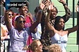 Blurry screenshot of CNN Sports report in 1998 of Venus defeating Hingis in Miami. Photo of the family box with Mark McIntosh, Serena Williams, Oracene WIlliams and Lyndrea Price. Everyone is on their feet cheering the victory after the winning point.