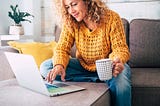 woman on sofa using laptop