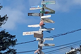 A sign post with arrows going in many directions.