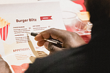 Judge Renel Domond, Co-Owner and COO of Juice Kings, carefully reviews the student menu at ‘The Wright Stuff’ food pitch competition, bringing expertise and discerning taste to the table (Photo by: Melissa Olguin)