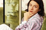 Donna Tartt lying on a couch and her book, “The Secret History”