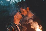A gay, interracial couple who is enjoying each other’s company outdoors.