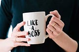 Woman’s hands holding a white mug that say, “Like A Boss”.