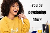 Happy African American Lady siting in front of a computer and an inscription of a question asking “what skill should you be developing now?”