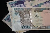 The Nigerian currency, naira notes in three denominations on a table.
