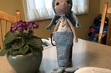 A crocheted doll with a blue sealskin cape covering her flowing green tresses and he magic fins.