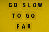 letters on yellow background saying go slow to go far