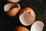 broken eggshells against a dark background