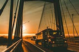 A truck crosses a bridge at sunset