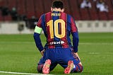 A picture of Lionel Messi kneeling in disappointment after a missed chance at goal.