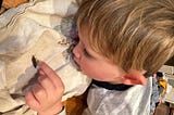 A little boy petting a slug. Author’s photo.
