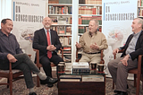 Three neuroscientists and a magician sitting in a library discussing consciousness and magic.