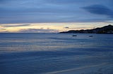 A subtle sunset that makes both the ocean and the sky look a grayish shade of blue.
