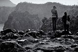 A black and white photo of two women standing on a cliff in Okinawa, Japan.