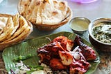 Picture of tandoori chicken, naan, and spinach raita.