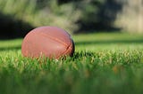 A football sits on a grass field