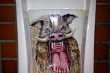 Photo of urinal with an intricate mural of a fierce, angry-looking wild boar painted inside it.