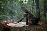 A woman, tarot cards and candles in a wood