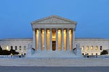 A panoramic photograph of the west facade of the Supreme Court of the United States building in Washington, DC, at dusk
