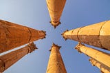 On point publishing chosen image of 7 ancient pillar columns streaming upwards towards the sky with the photograph taken from the ground between them all